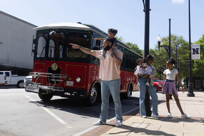 Family standing near trolley