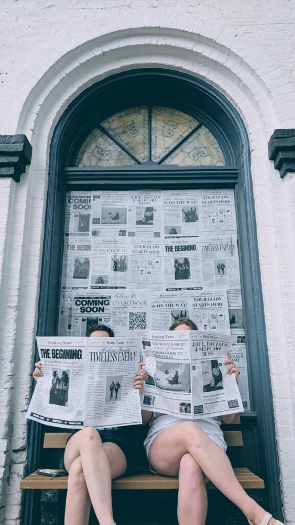 Exterior Shot of historic building with owners reading newspapers.
