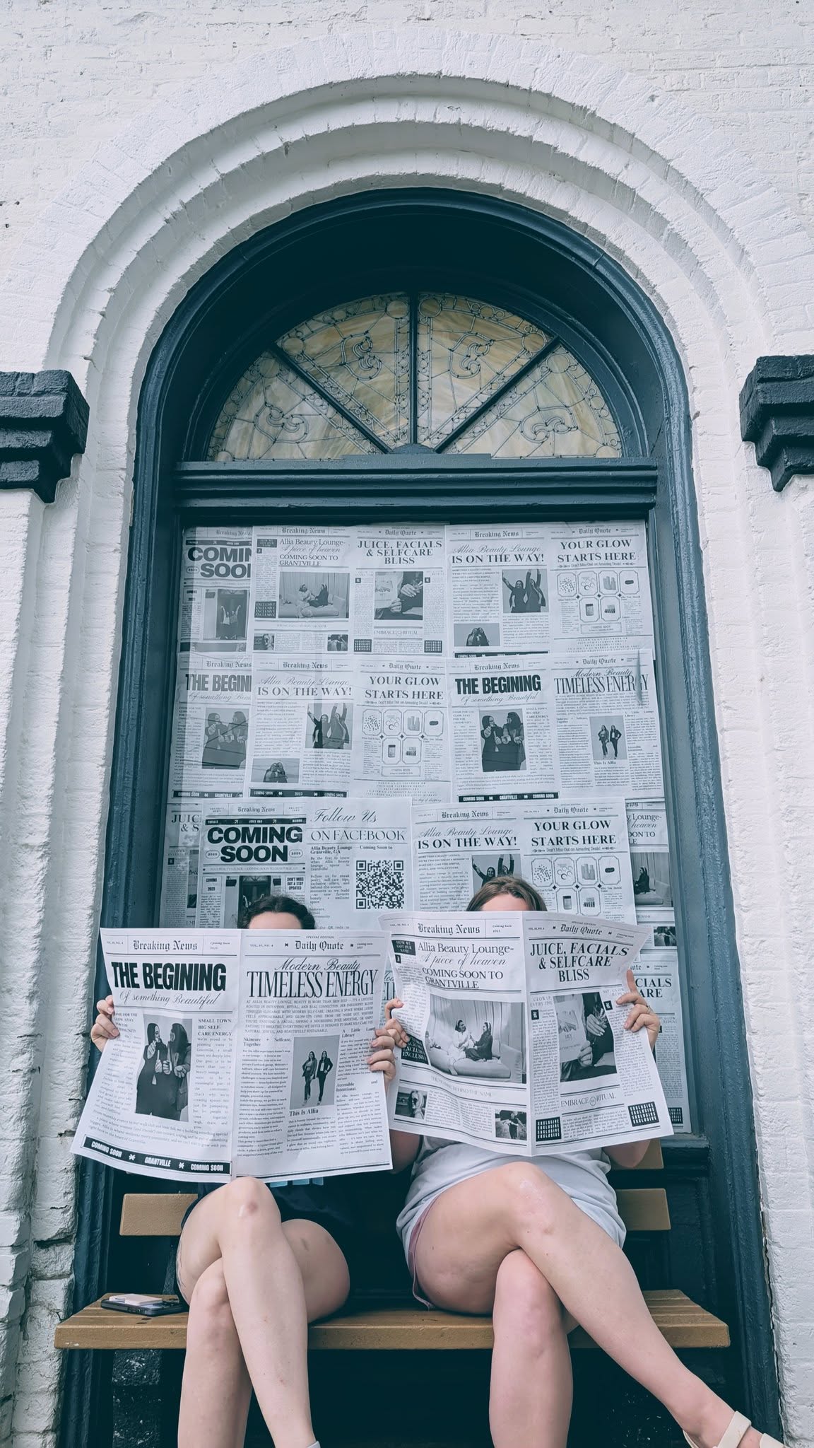 Exterior Shot of historic building with owners reading newspapers.