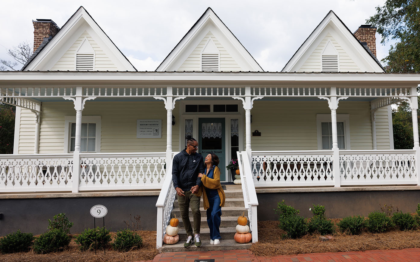 Couple in front of historic home at fall