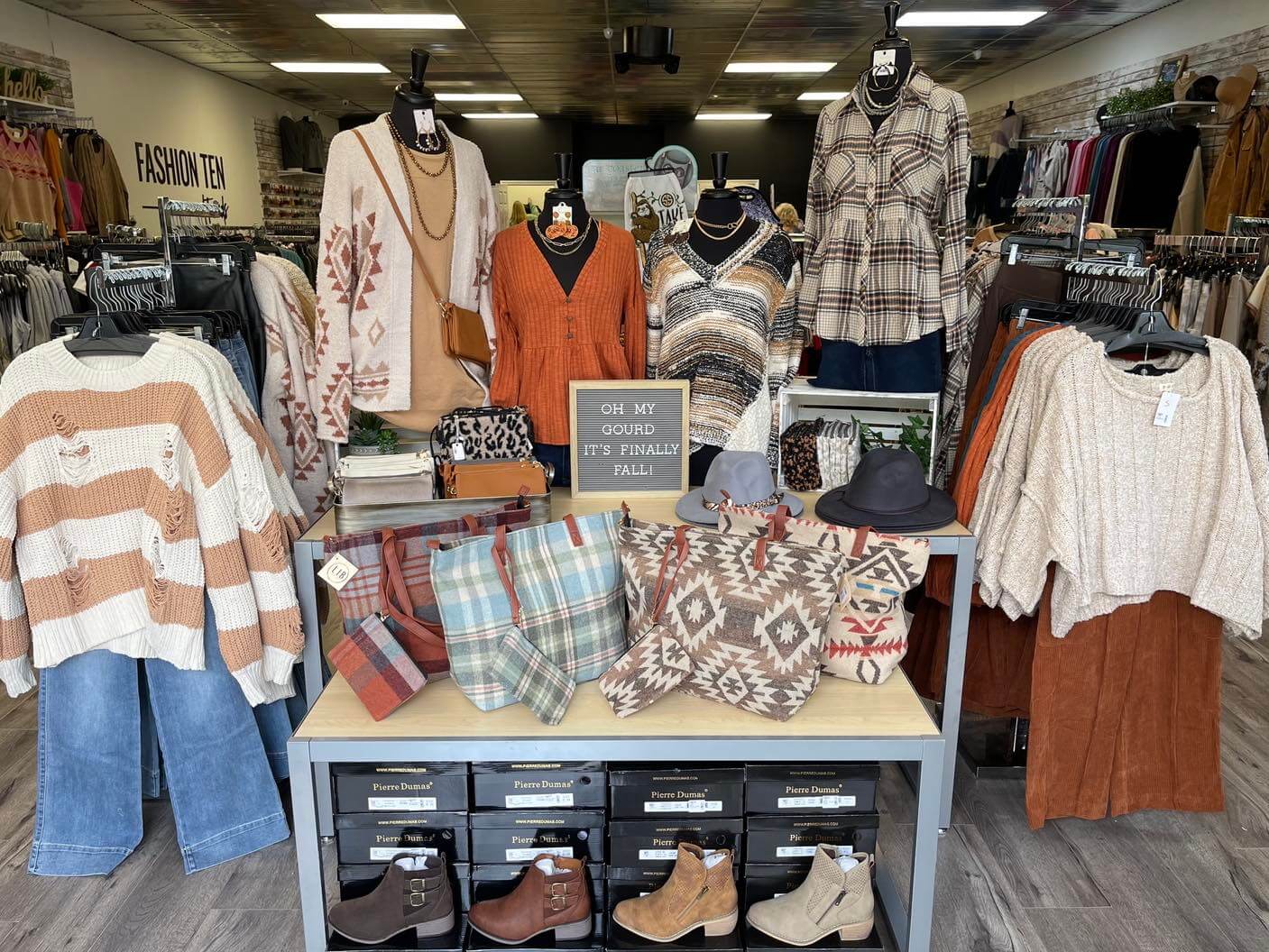 Display table of accessories surrounded by fall clothing